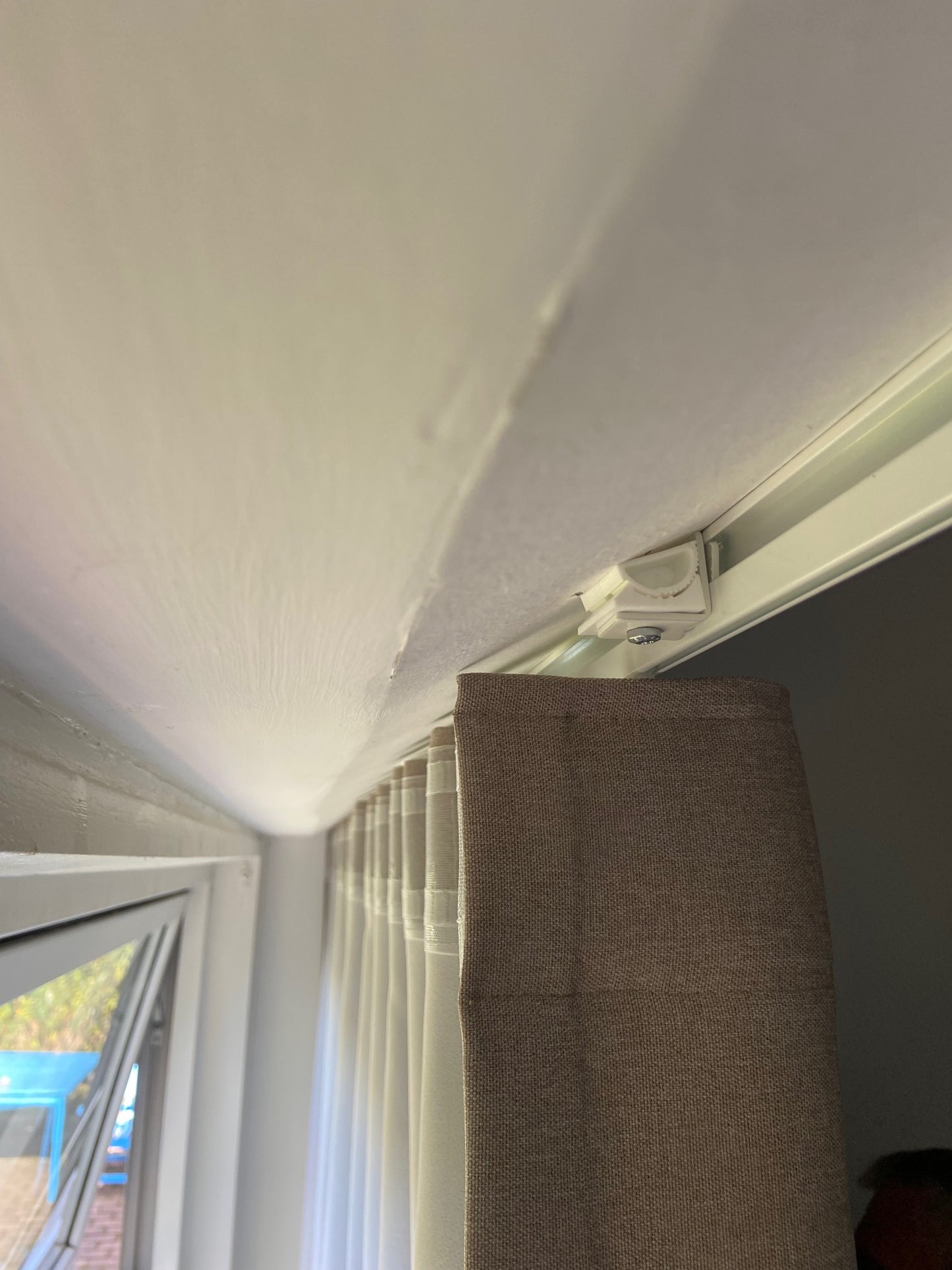Beslag til montering af gardinskinner på skrå lofter